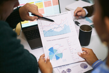 Caucasian man and Black woman analyzing financial charts and graphs during business meeting,...