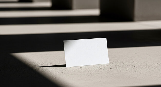 Business card mockup on concrete surface with geometric shadow cast