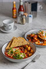 shakshuka with toast and roasted potatoes in bowl