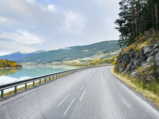 A winter landscape along the Sognefjellsvegen road in Norway, featuring snow-covered mountains and a vast, serene terrain.