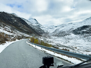 A winter landscape along the Sognefjellsvegen road in Norway, featuring snow-covered mountains and a vast, serene terrain.