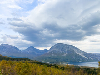 Fototapeta premium Dramatic landscape of saguenay fjord with sun rays piercing through the cloudy sky, creating a scenic view