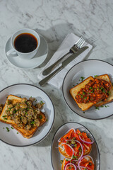 coffee with trio of gourmet toasts on marble table in hard light