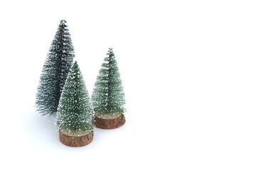 On a white background there are three small decorative Christmas trees.