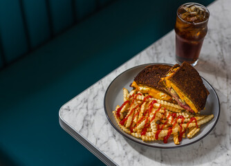 grilled cheese sandwich with meat on rye and crinkle-cut fries in diner