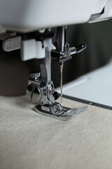 a close-up of a sewing machine presser foot resting on fabric