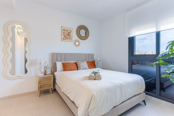 Contemporary bedroom with soft tones, decorative wall art, and large window with natural light