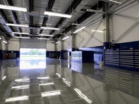 Clean Empty Racing Garage Interior with Open Door to Track