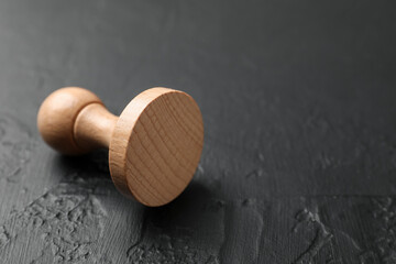 One wooden stamp on dark textured table, closeup. Space for text