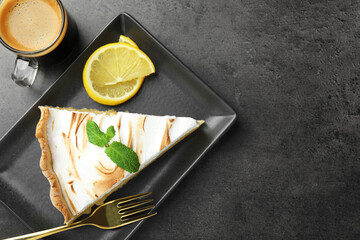 Slice of tasty lemon meringue tart with mint served on black table, flat lay. Space for text