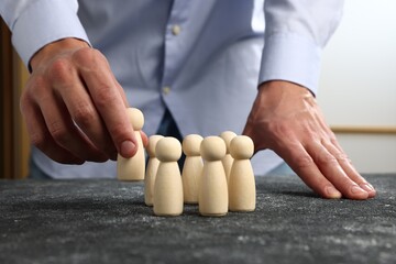 Man with human figures at black table, closeup