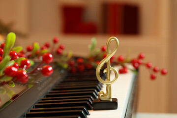 Golden treble clef and Christmas decor on piano indoors, space for text