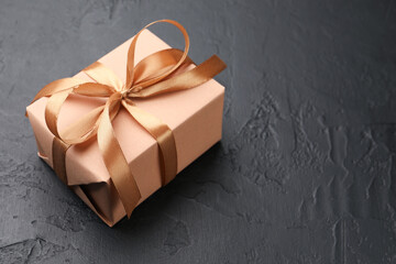 Beautiful gift box on black background, closeup. Space for text