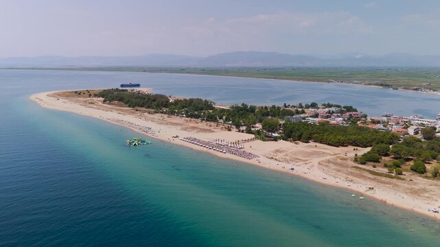 Aerial drone fly-down shot towards the beautiful long white sand and turquoise blue waters of Keramoti Blue Flag Beach, Kavala, Eastern Macedonia, Greece.