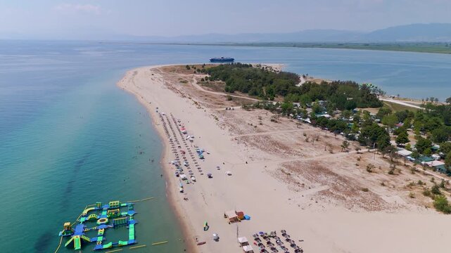 Top-down aerial drone shot over the expansive white sands of Keramoti Blue Flag Beach and the clear turquoise waters of the Thracian Sea, Kavala, Greece.