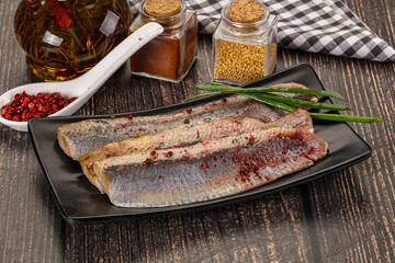 Salted marinated herring fillet with spices