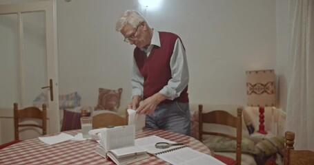 An elderly man in his comfortable home peels an orange, appearing happy and content. He enjoys a peaceful moment, reflecting daily life and simple pleasures in retirement.