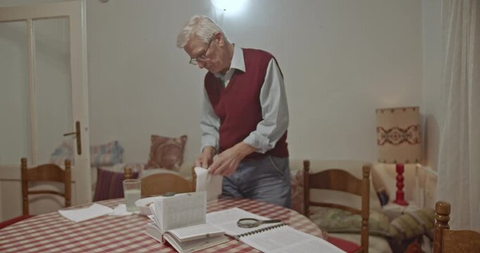 An elderly man in his comfortable home peels an orange, appearing happy and content. He enjoys a peaceful moment, reflecting daily life and simple pleasures in retirement.