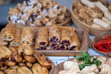 Variety of baked goods, delicious baked items accompanied by fresh vegetables displayed invitingly