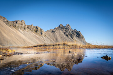Vestrahorn rises 454 meters from the black sand coast, a basalt and gabbro formation shaped by glacial and marine erosion in Iceland&rsquo;s southeast.