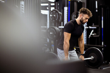 Naklejka premium Weightlifting session at the gym with a focused athlete preparing to lift