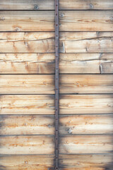 Old wooden wall with vertical metal beams.