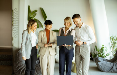 Group of professionals collaborating with a laptop in a modern office space