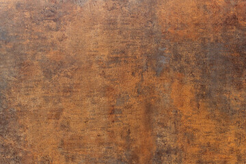 A close-up of the surface of an artificial stone slab on the facade of a modern building. The panel is orange and brown, similar to rust. Background. Texture.