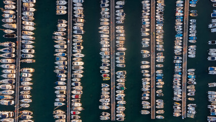 Abstract aerial view of boats moored in the historic port of Koper, Slovenia. Top-down view of the vessels neatly arranged in the water