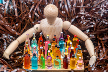 concept of drink choice, a wooden mannequin surrounded by unwound magnetic tape covers with hands an pallet of goods with different beverage bottles