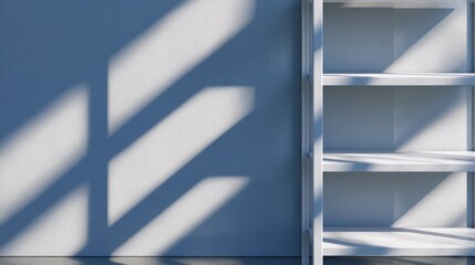 Obraz premium Minimalist interior featuring a white shelf against a blue wall with dramatic shadows in the background