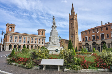 Piazza Aurelio Saffi in Forlì, featuring a tall brick tower, a monument, and historic palazzo architecture.