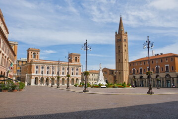 Wide view of Piazza Aurelio Saffi in Forlì, featuring the tall brick tower and historic palazzi.