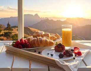 A scenic breakfast on a tray, complete with pastries, fruit, juice, and a mountain view at sunset