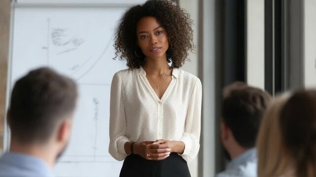 Smiling businesswoman giving a presentation to a diverse audience