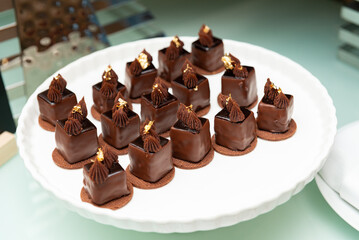 A beautifully arranged plate of luxurious chocolate desserts adorned with gold leaf. perfect for fine dining, showcasing gourmet pastry artistry.