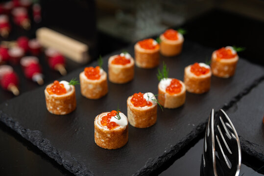 A beautifully arranged selection of gourmet appetizers featuring salmon roe on a slate platter. this elegant presentation highlights refined culinary craftsmanship and exquisite taste.