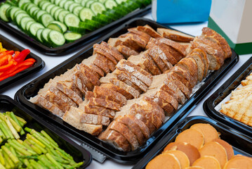 A vibrant assortment of food displayed for events, featuring sliced bread, fresh vegetables, and various appetizers. perfect for social events and celebrations.