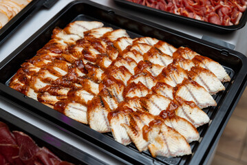 Grilled marinated fish display. A tray of succulent grilled fish fillets, expertly arranged and glazed with a rich marinade. 