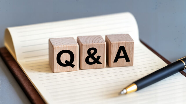 Wooden blocks spelling q & a on a notebook with a pen perfect for illustrating question and answer sessions faq pages or educational content about learning and information resources