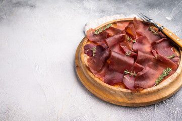Cecina meat slices, spanish beef jamon on wooden tray white background. top view
