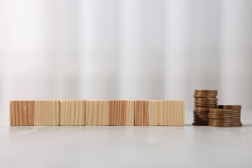 Alimony. Blank cubes and coins on grey marble table, closeup