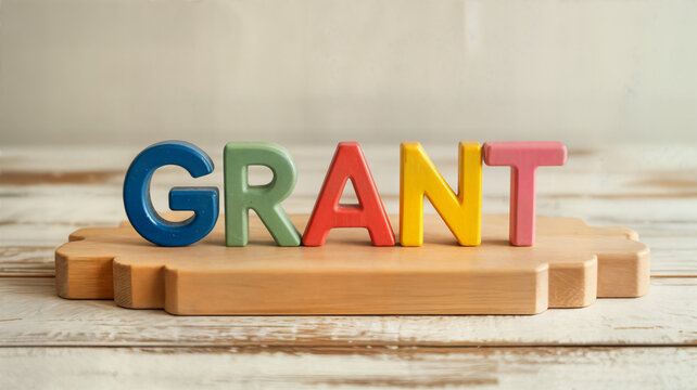 Colorful wooden letters spelling "grant" on a wooden surface ideal for educational materials funding announcements or creative project visuals showcasing support and opportunity