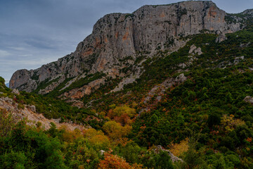 Naklejka premium Sheer limestone wall above autumn valley