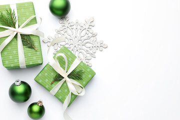 Beautiful Christmas composition with gifts and decor on white background, flat lay. Space for text