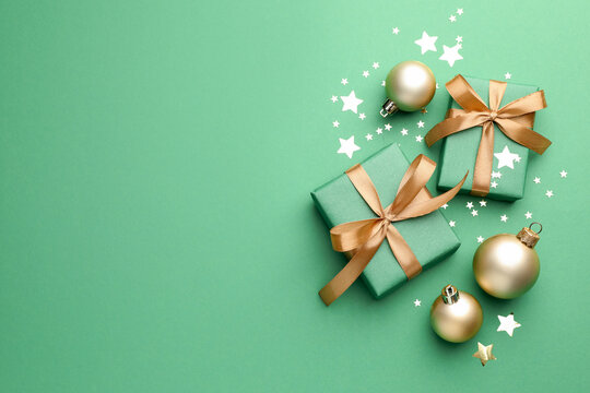 Beautiful Christmas composition with gifts and decor on green background, flat lay. Space for text - Powered by Adobe