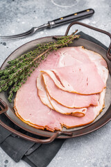 Thinly sliced pork ham, smoked meat. grey background. top view
