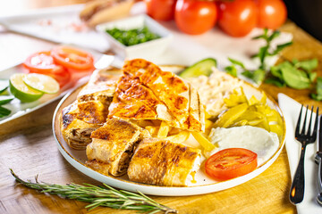 Chicken roll breast stuffed with butter, garlic and dill. Served with baked potato slices and fresh herbs.