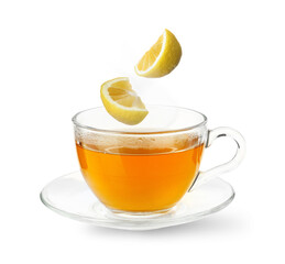 Citrus drink for health boosting. Lemon pieces falling into cup on white background. Cold season remedy