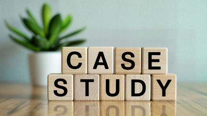 Wooden blocks spelling out "case study" on a table ideal for illustrating business analysis educational content or marketing materials with a blurred plant in the background providing a natural touch